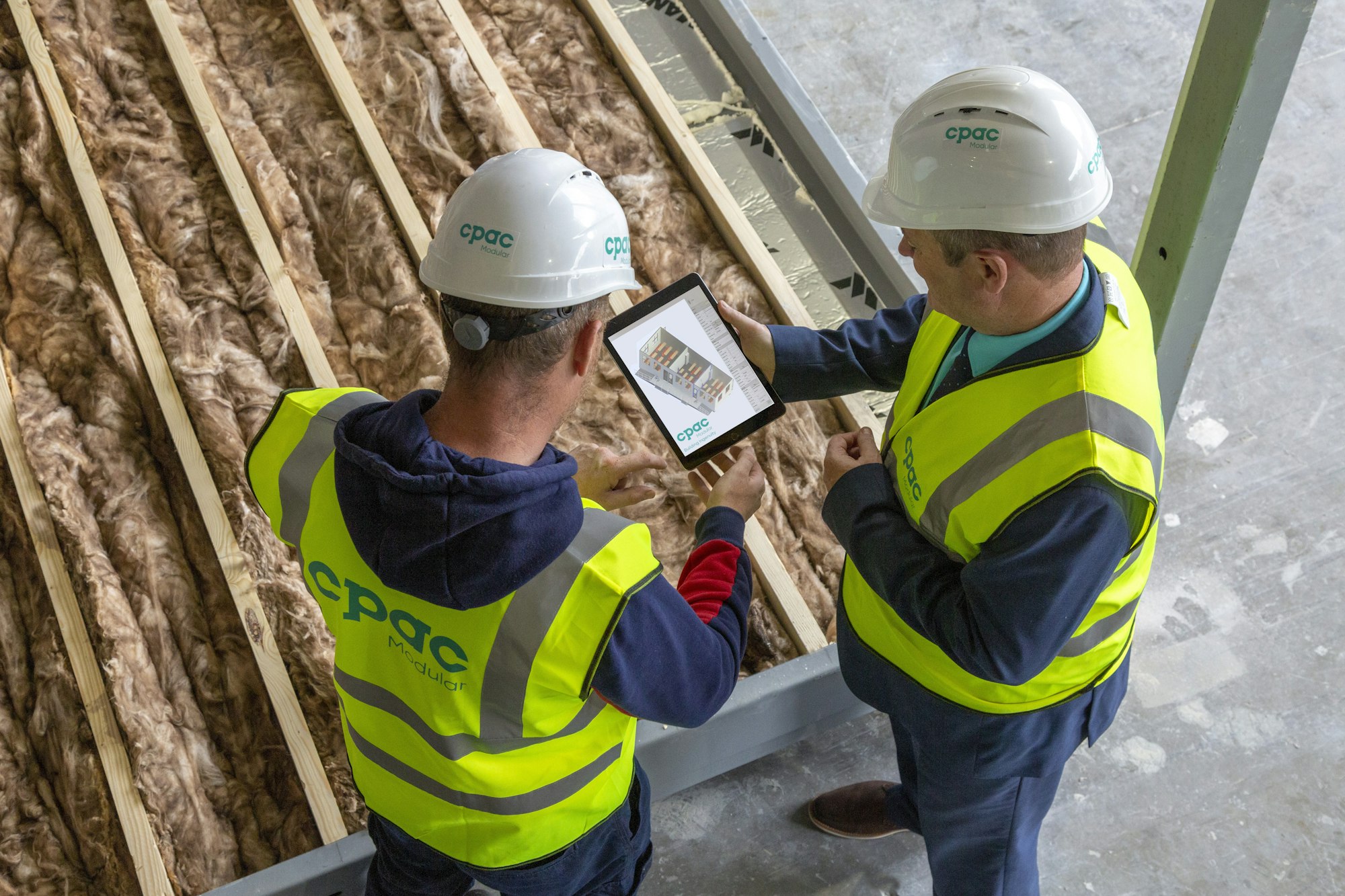 Two contractors reviewing plans on a tablet Two contractors reviewing plans on a tablet