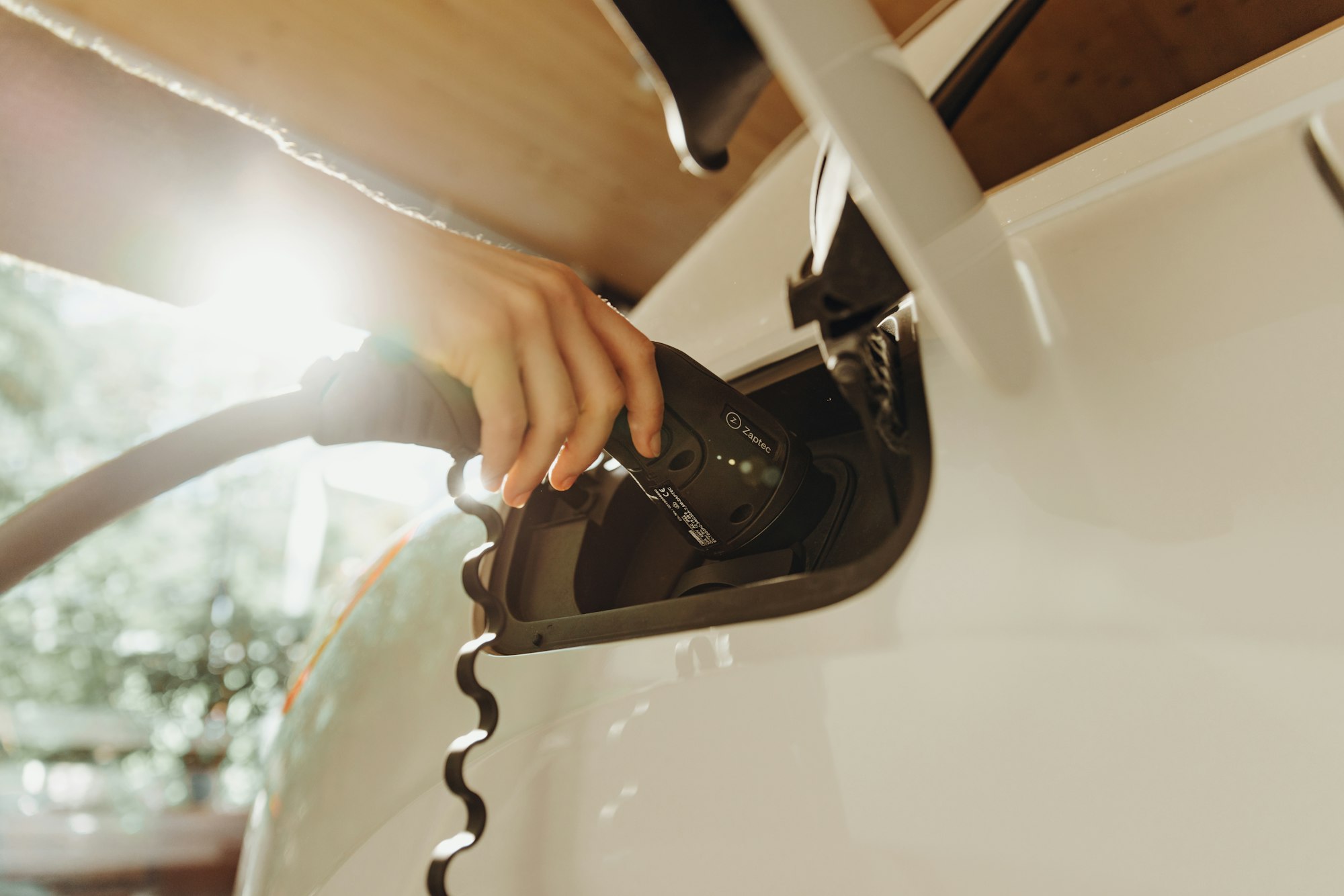 Charging cable plugged into an electric vehicle Charging cable plugged into an electric vehicle